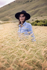 Giovane donna caucasica con cappello in un campo di grano