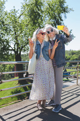 Positive tourists. Joyful aged people enjoying their walk while travelling together