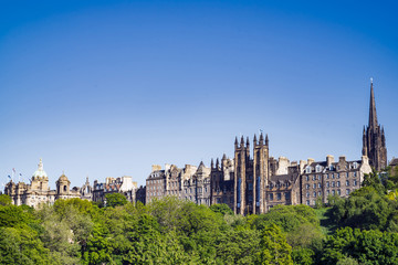 Fototapeta na wymiar A view of Edinburgh Old Town, from Princes Street. Buildings left to right, Original head office of the Bank of Scotland, General Assembly Hall of Church of Scotland, Tron Kirk spire.