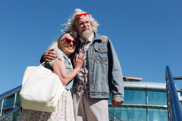 My support. Cheerful nice woman standing together with her husband while having a walk with him