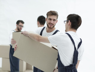 Portrait of movers holding box smiling isolated on white backgro