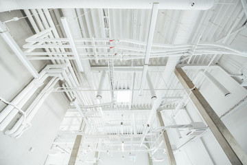 White pipes and cables in industrial building