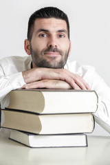 Portrait of young handsome student with pile of books, education concept, studio isolated picture