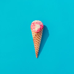 Pink and white ice cream on pastel blue background. Summer minimalism. Flat lay.