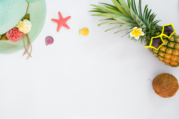 Hipster pineapple fashion with tropical fruit, straw hat, sea shells and starfish. Summer vacation background concept. Top view, flat lay