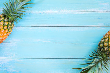Tropical pineapple on wood plank blue color. frame layout summer vacation background concept.