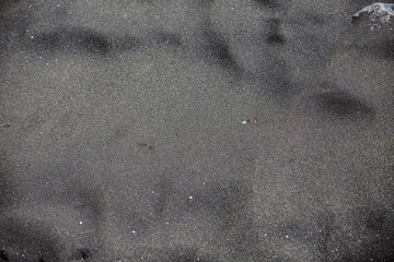 Black volcanic beach sand texture background