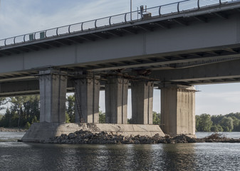 Fototapeta na wymiar Supports of an automobile bridge. Concrete supports. Bridge under construction. Urban landscape