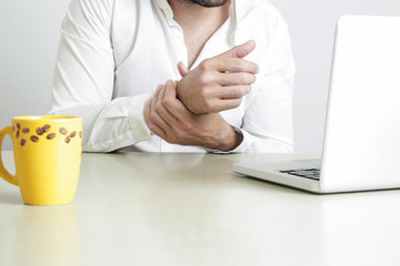 Wrist injury, young employee with Carpal tunnel syndrome symptom at the office desk