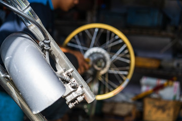 Fototapeta premium Automobile mechanic repairing motorcycle in bike repair shop