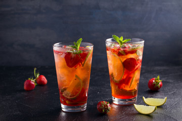Strawberry mojito cocktail with berries, lime and mint. Summer berry cocktail on black background. space for text, horizontal