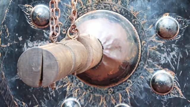 blow to the oriental gong at Buddhist monastery