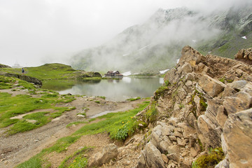 Cabin surrounded by clouds near glacier lake in the mountains in Europe 