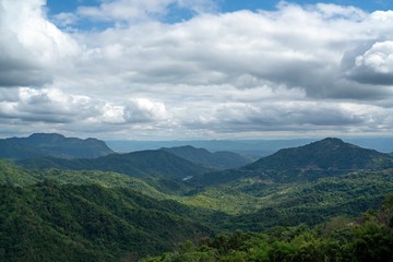 Scenic view of a Green mountains landscape with sunlight through beautiful mostly clouds on blue sky.