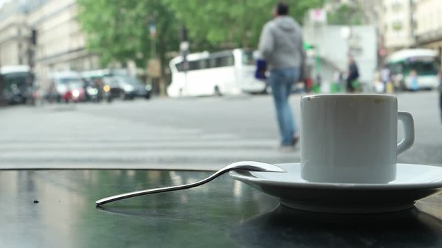 May 23, 2018 Paris, France. A cup of coffee on a little table in cafe against the background of the street