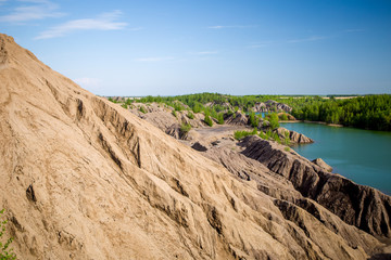 Photo of picturesque hilly area with vegetation and blue lake