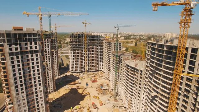 Aerial shoot of construction site with tower cranes. Construction drone footage