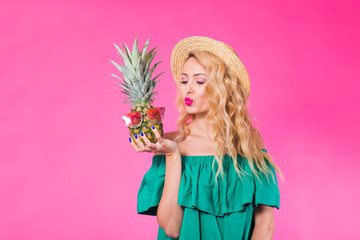 Fashion portrait young beautiful woman with pineapple over pink background