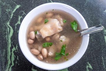 Taiwan's distinctive famous snacks: Peanut pork knuckle(pig's trotter) soup in a white bowl on stone table, Taiwan Delicacies, Taiwan Street Food