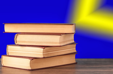 Books stacked vertically on a blue background