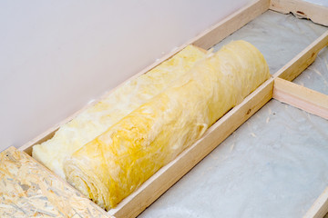 roll of mineral wool lying on the wooden floor