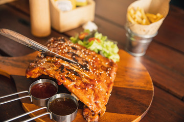 Roasted sliced barbecue pork ribs, focus on sliced meat. Delicious barbecued ribs seasoned with a...