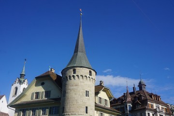 Fototapeta na wymiar Stone made tower in town in Switzerland