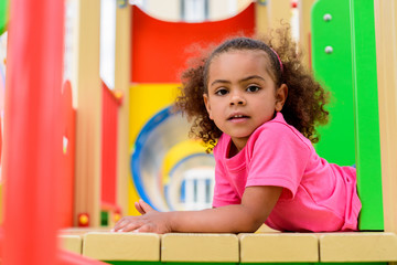 Fototapeta na wymiar Portrait of curly African American little child having fun at playground