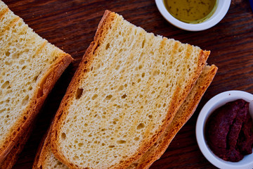 Gourmet Italian snack, restaurant menu ,food photo concept. Chef's olive tapenada and crunchy rye baguette in restaurant serving.