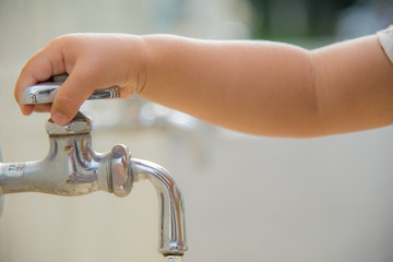 水道で手を洗う子供の手