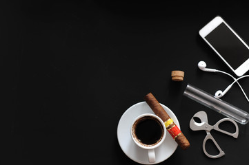 cigar headphones for coffee, coffee for coffee in coffee beans, mug of white coffee, black background. View from above. Copy space