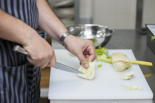 The cook cuts greens for salad Close-up