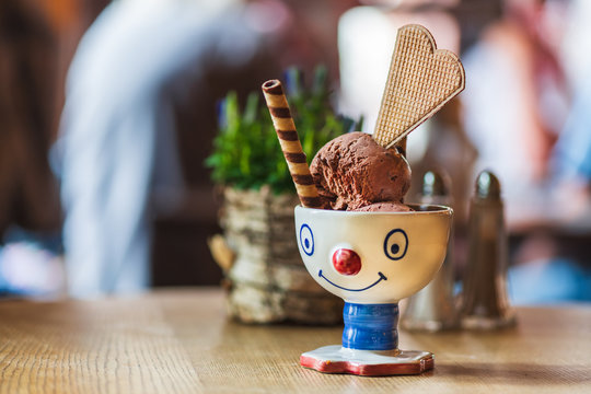 Kinder Schokoladen Eis in einem Kinder Clown Becher mit Waffeln serviert in einem Restaurant 