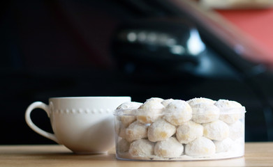 Snow White Cookies or Puteri Salju and a cup of tea with wood background.