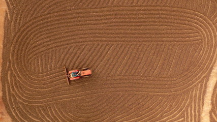 Tractor spreading coffee for drying