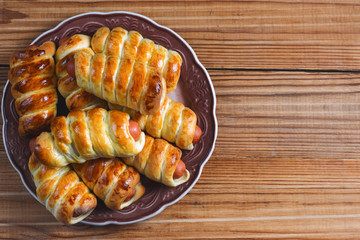 Sausages in the dough on a wooden table