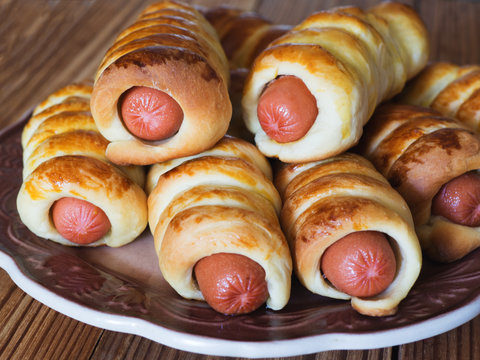 Sausages in the dough on a wooden table