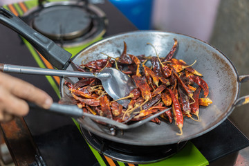 cooking dried red chilies in pan