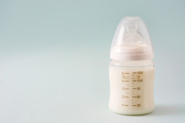 Baby bottle and milk on gray background

