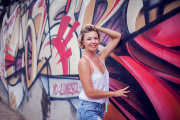 Naklejka premium Portrait of beautiful woman posing on colorful wall background outdoors