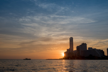 Naklejka premium Sunset on the maritime horizon with boat in the modern part of Cartagena. Colombia