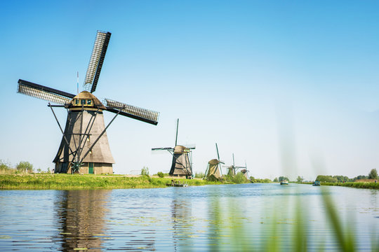 Traditional Holland landscape with old windmills and water canal.