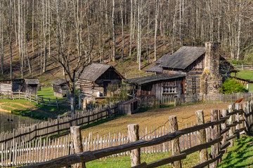 A rustic log cabin farm or homestead with a fence leading the way.