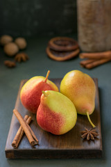 Yellow pears on a wooden board with cinnamon and anise