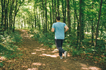 adult young man running in woods. copy space