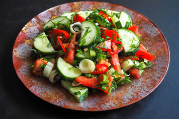 Cucumber salad and tomato with chili pepper and green onions seasoned with olive oil.