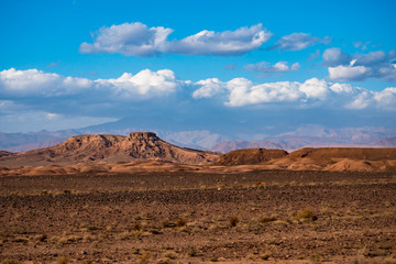 African landscape of Atlas mountain in Sahara desert with bright blue sky and clouds