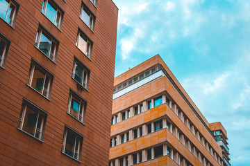 red and orange apartment or office buildings in a row on a summer day