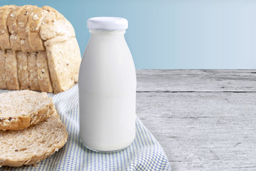Fototapeta na wymiar A glass bottle of milk with sliced bread on cloth isolated on wooden background for food and healthy concept. with copy space for text.