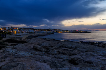 Beautiful cloudscape over sea, sunrise shot. Waves among the rocks, rocks on horizon. Crete, Greece